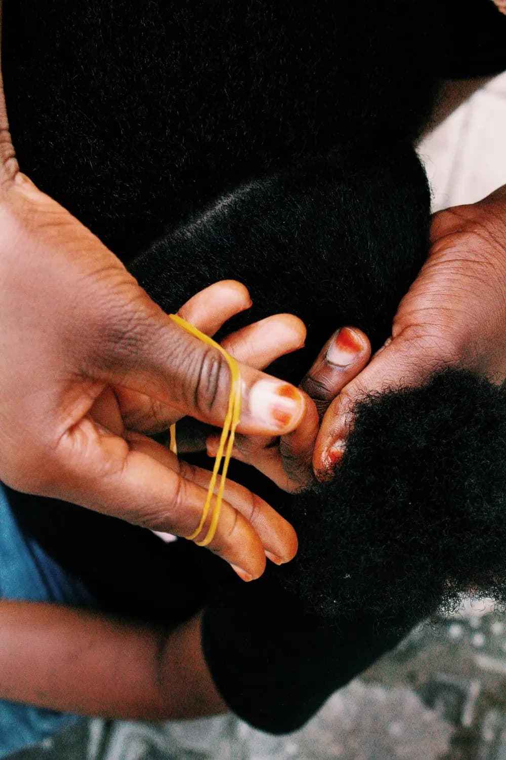 Une mère tresse les cheveux de sa fille.