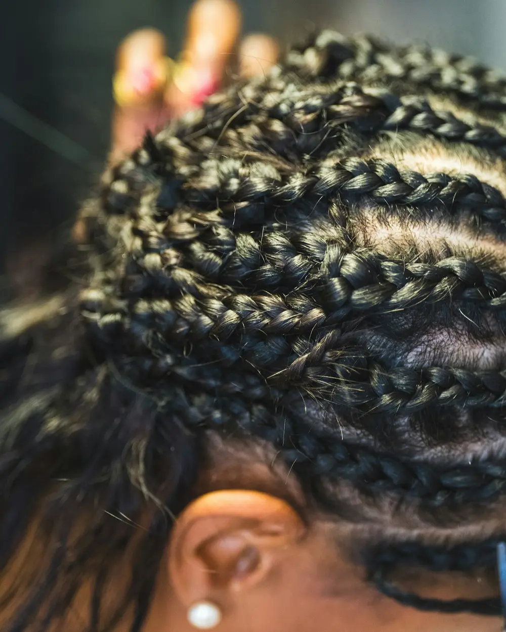 Mains en train de tresser des cheveux.
